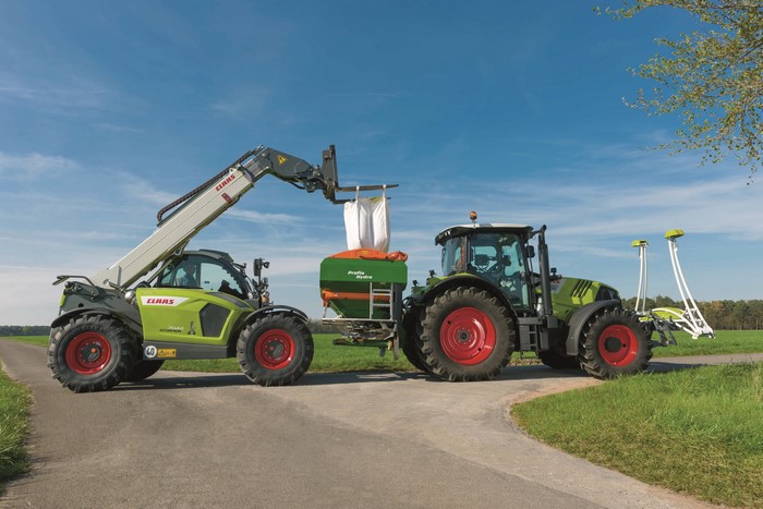 Claas Scorpion 7044 loading Claas Arion 550 with fertilizer