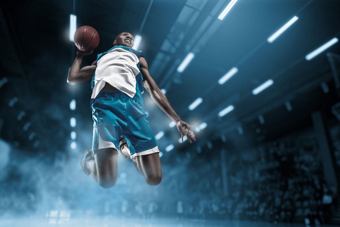 Basketball player jumping with ball