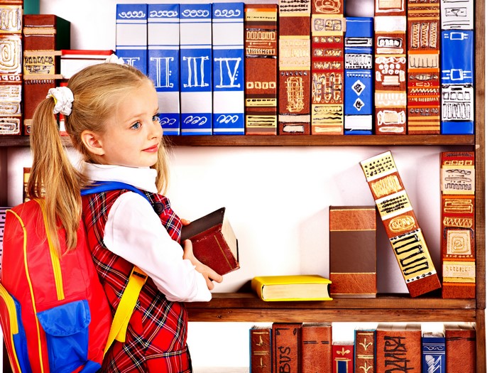 Little girl with backpack and books