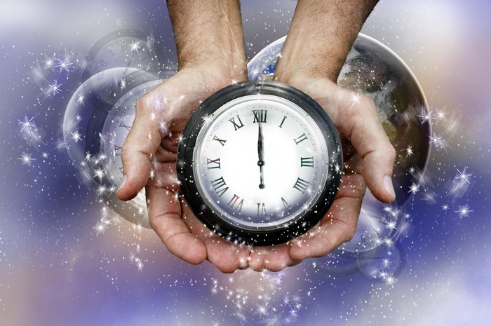 Hands holding a clock with Earth and stars