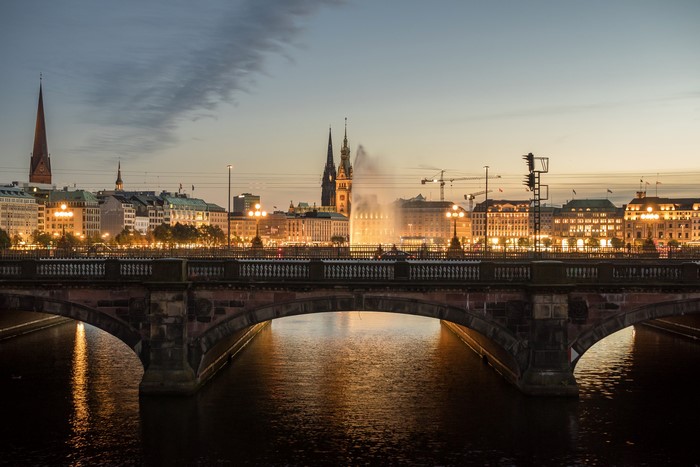 Hamburg skyline with bridge over river at dusk