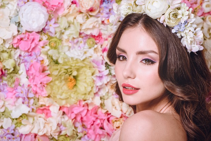 Woman with flower crown against floral background