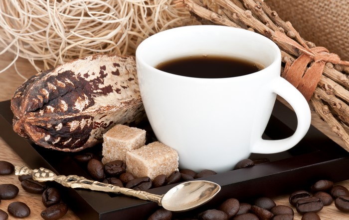 Coffee cup with cocoa pod, sugar cubes, and spoon