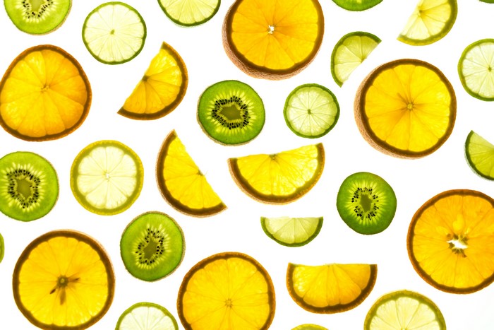 Slices of citrus fruits and kiwi on a white background