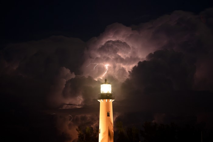 Lighthouse during a lightning storm at night