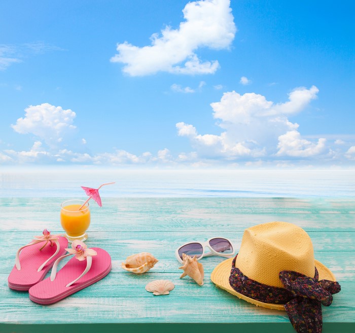 Beach accessories on a wooden table by the sea