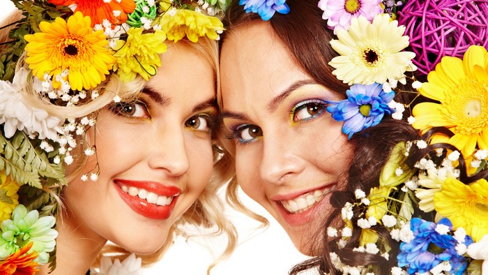 Two smiling women with flowers in their hair