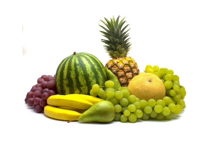Assortment of fresh fruits including watermelon, pineapple, grapes, bananas, pears, and melon