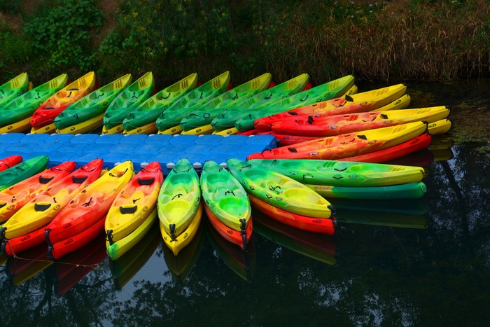 Colorful kayaks lined up on a floating dock