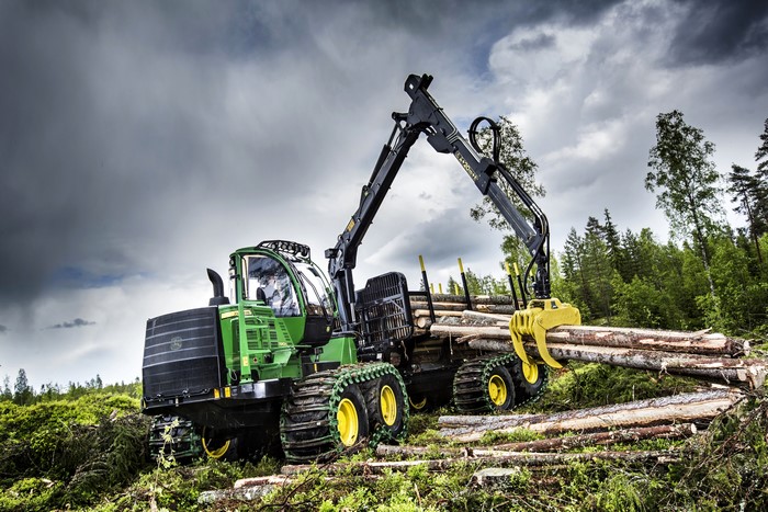 John Deere Forwarder loading logs in forest