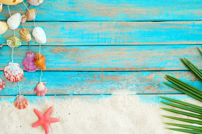 Shells and starfish on blue wood planks and sand