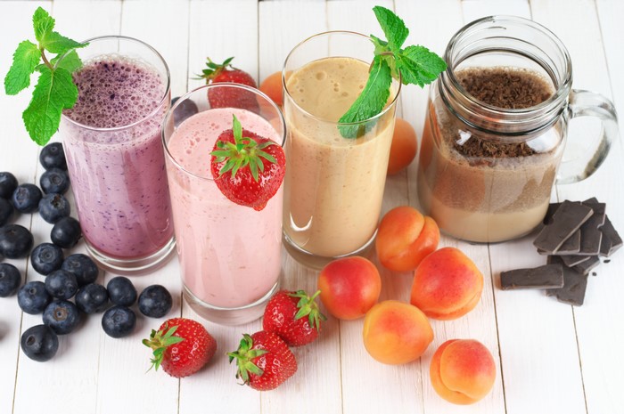 Four fruit smoothies with fresh fruit and chocolate