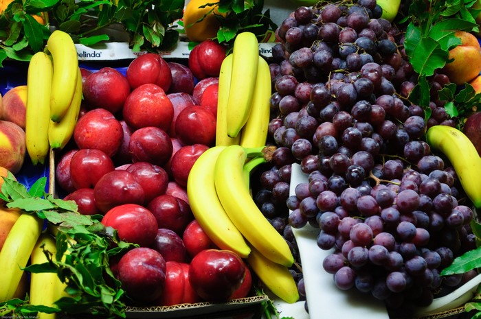 Bananas, Plums, and Grapes at a Market