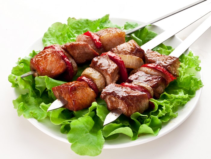 Meat shashlik on skewers with vegetables on a plate
