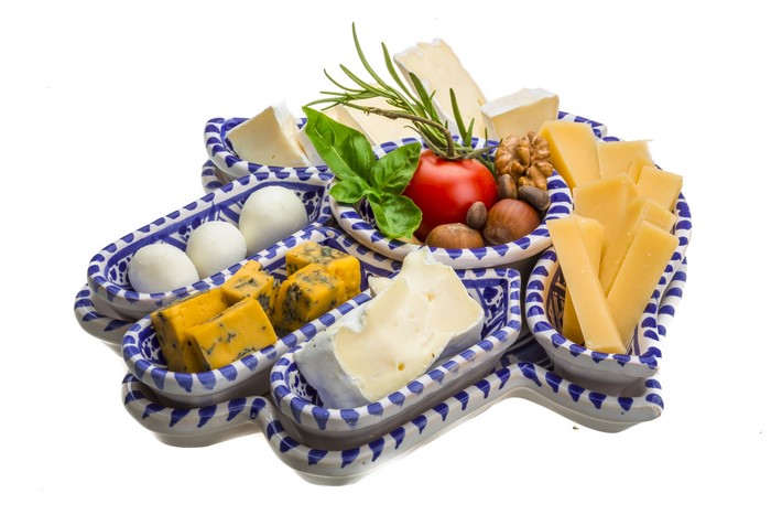 Cheese platter with tomatoes, nuts, and herbs
