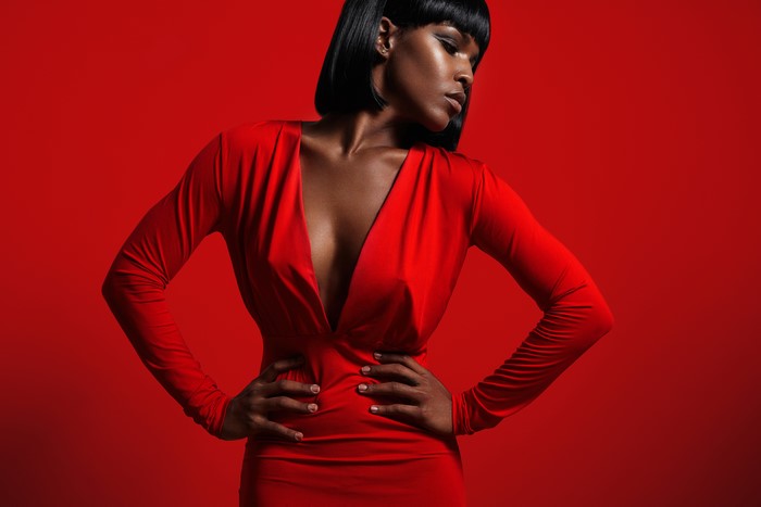 Woman in red dress with décolletage on red background