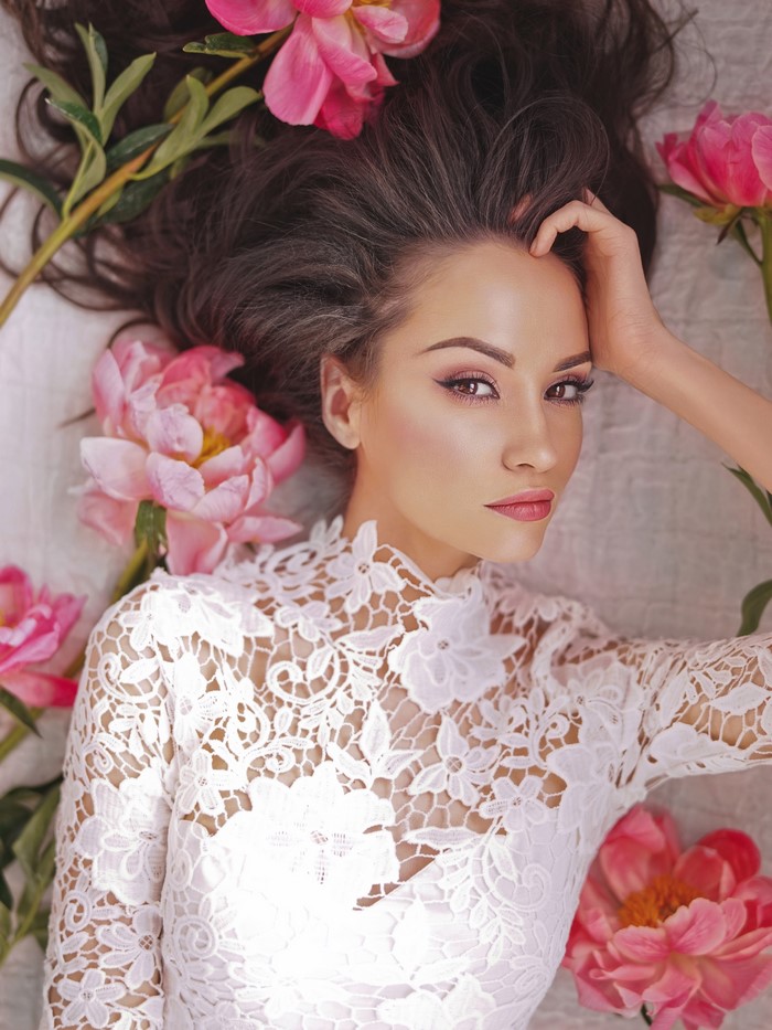 Woman with brown hair and pink peonies