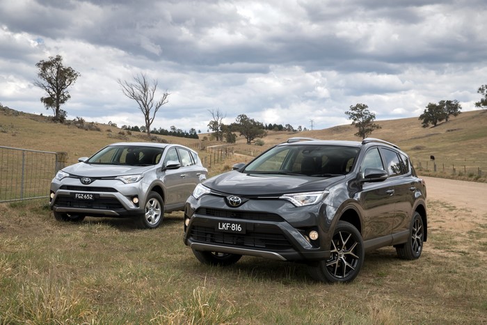 Two Toyota RAV4 SUVs parked on a grassy hill