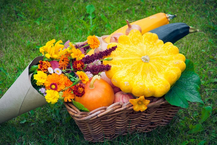 Autumn harvest in a wicker basket with flowers