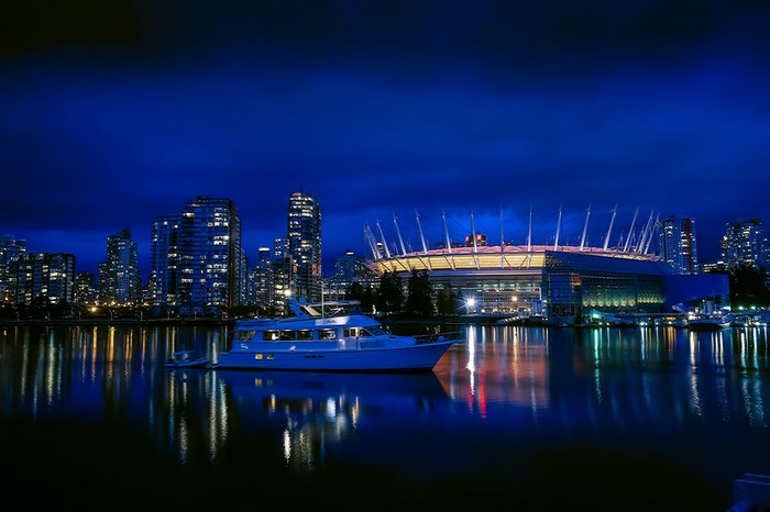 Vancouver skyline with stadium and motorboat at night