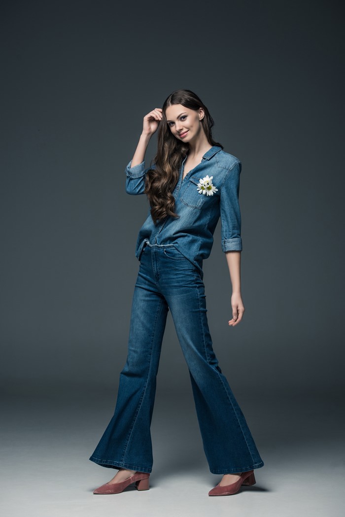 Woman in denim shirt and jeans with flower