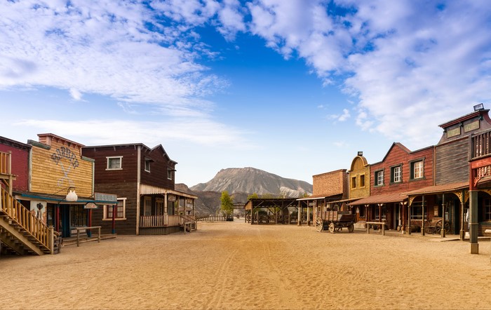 Western town with wooden buildings and a mountain backdrop