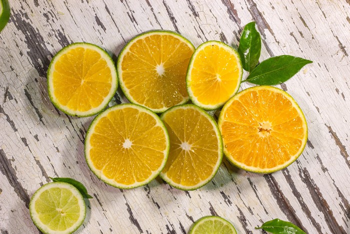 Slices of oranges and limes on a wooden table
