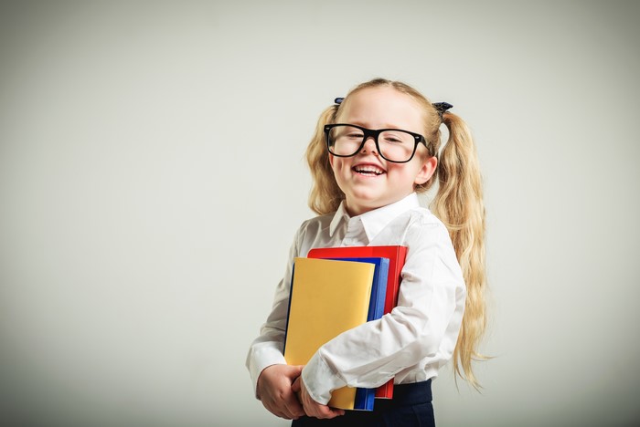 Little girl with glasses holding books