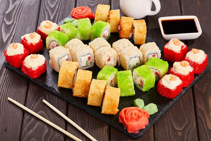 Sushi platter with soy sauce and chopsticks on wood