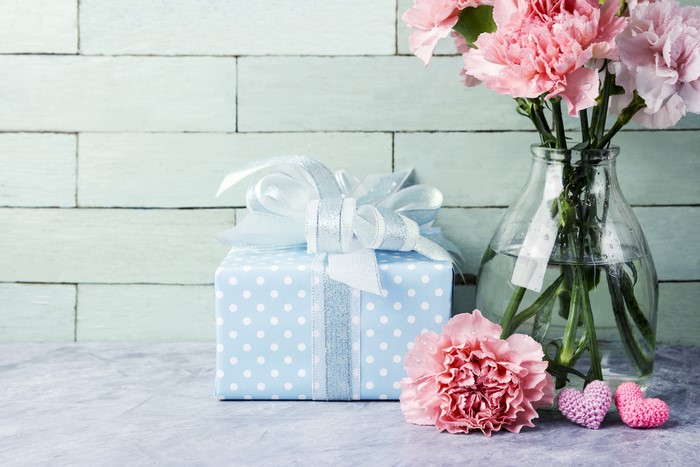 Gift box with pink carnations in a vase