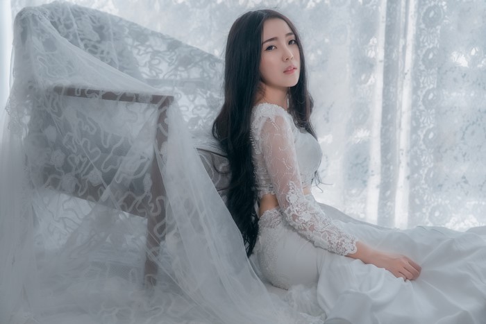 Brunette girl in white dress sitting