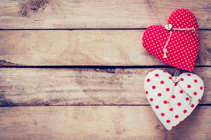 Two polka dot hearts on wood planks
