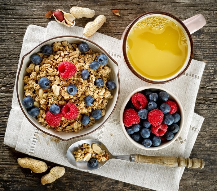Muesli with Blueberries and Raspberries, Orange Juice, and Peanuts
