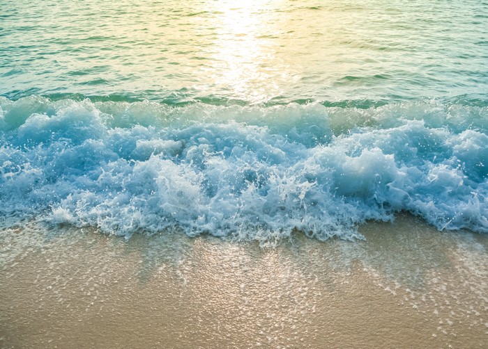 Ocean waves crashing on a sandy beach