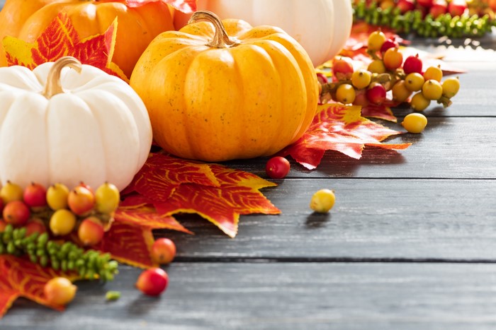 Pumpkins and autumn leaves on wood planks