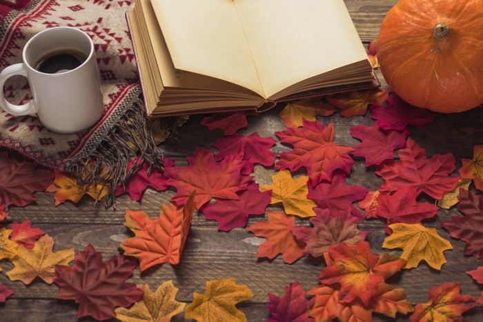 Autumn scene with book, coffee, and pumpkin
