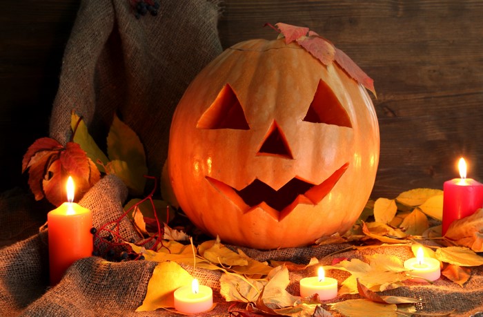 Halloween pumpkin with candles and foliage