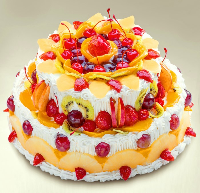 Multi-tiered fruit cake with strawberries and cherries