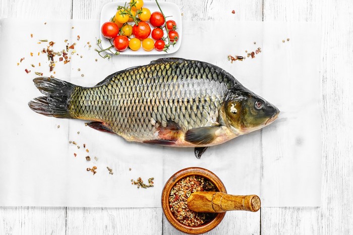 Whole raw fish with cherry tomatoes and spices