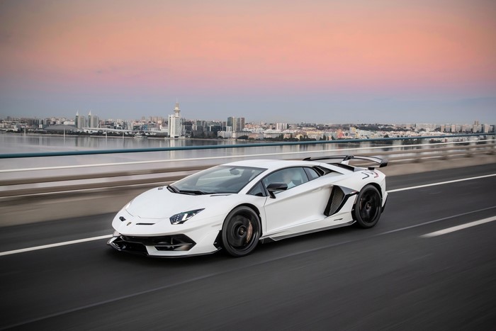 White Lamborghini Aventador SVJ driving on a bridge