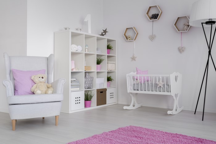 Children's room with armchair, crib, and shelving unit
