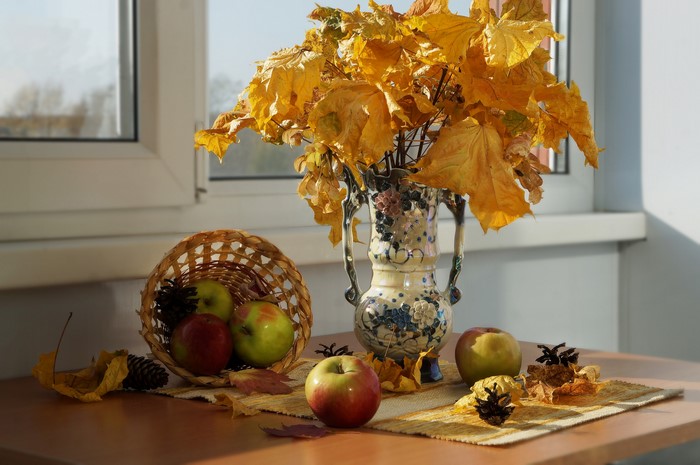 Autumn still-life with apples, vase, and fallen leaves