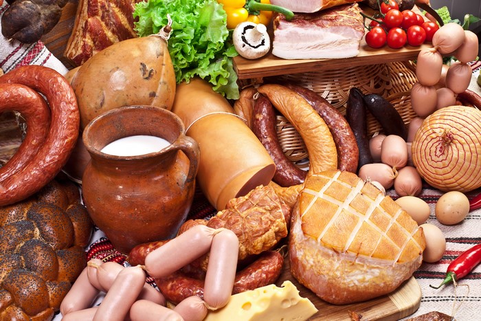 Meat products, sausages, vegetables, and dairy in a rustic display