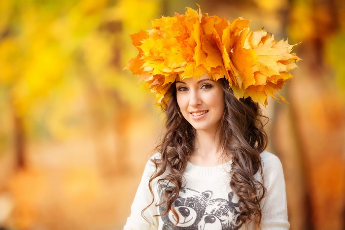 Woman with autumn leaves crown in forest