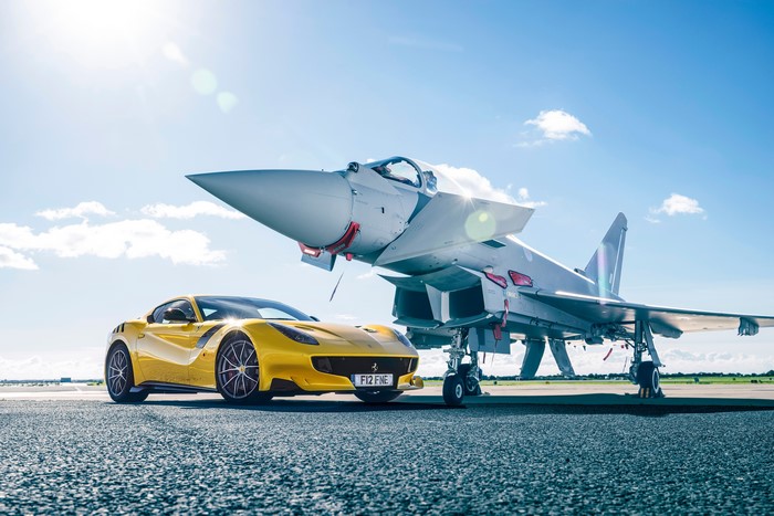 Yellow Ferrari F12 TDF next to a fighter jet