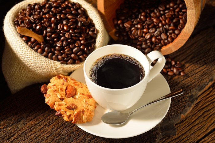 Coffee cup with cookies and coffee beans