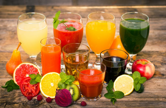Assortment of Fresh Juices and Fruits on Wooden Table