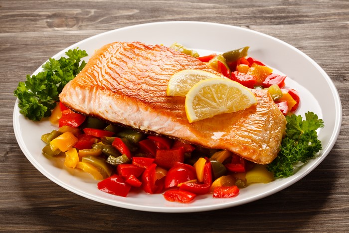 Salmon with vegetables and lemon on a plate