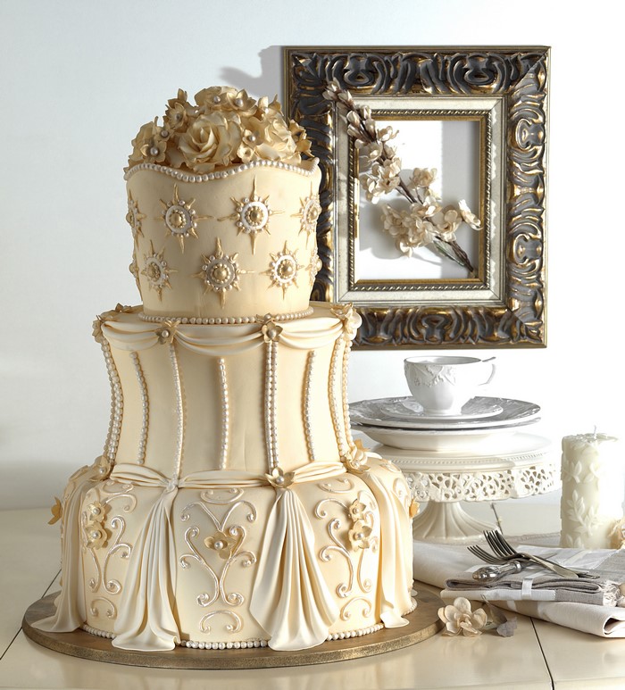 Elegant three-tier cake with floral and pearl decorations