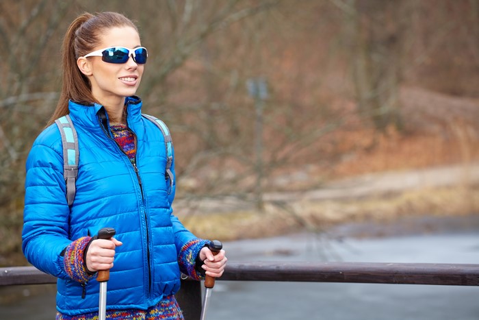 Woman with sunglasses and hiking poles